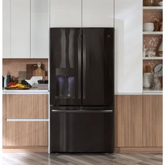 a black refrigerator freezer sitting inside of a kitchen