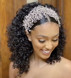 a woman with curly hair wearing a headpiece