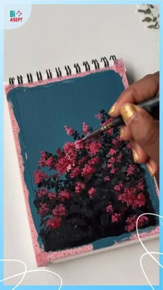 a person is painting flowers on a piece of paper