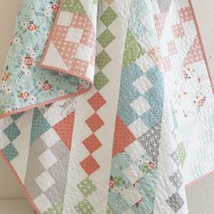 three quilts are stacked on top of each other in different colors and patterns,