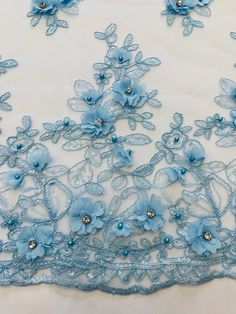 blue flowers on white fabric with beadings and sequins in the center