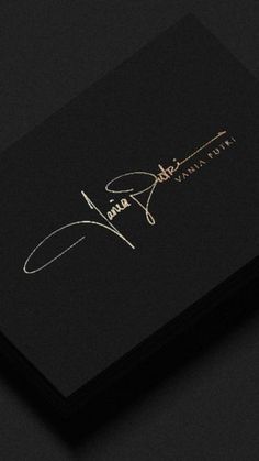 a black business card with gold lettering on it