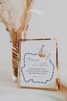 there is a card with a sailboat on it next to a vase filled with feathers