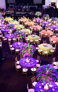 tables and chairs are set up for an event with purple linens, green centerpieces, and candles