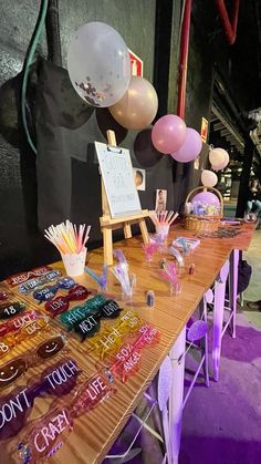 a wooden table topped with lots of balloons