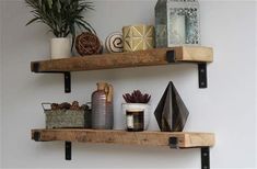 two wooden shelves with decorative items on them and one shelf holding candles, vases and potted plants