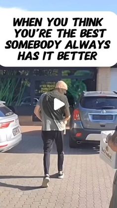 an older man standing in the middle of a parking lot with his back to the camera