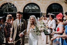 a bride and groom walking through confetti thrown by their guests at the wedding