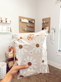 a person holding up a bag with buttons on it in front of a mirror and other items