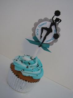 a cupcake with blue frosting and a cheerleader topper