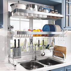 a kitchen with blue cabinets and white countertops has pots, pans, and utensils on the rack