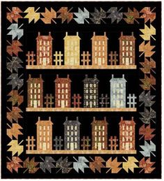 a quilted wall hanging with buildings and leaves on the shelves in front of it