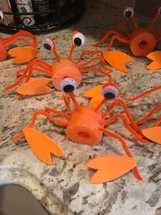 some orange plastic crabs with googly eyes on a counter