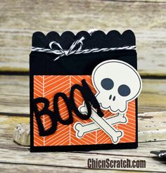 a halloween treat bag with a skull and crossbones on it, sitting on a wooden table