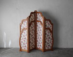 a room divider made out of wood and fabric with floral designs on the sides