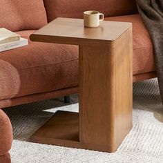 a wooden table sitting on top of a carpeted floor next to a couch and chair