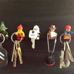 several lego keychains with different types of keys attached to them, sitting on a black surface