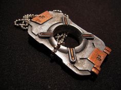 a close up of a metal object with chains on it's sides and two small tags attached to the clasps