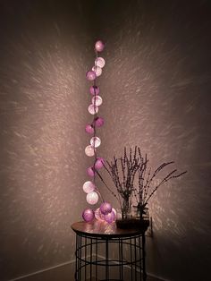 a table with some flowers on it next to a wall