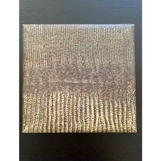 a brown and white box sitting on top of a wooden table next to a black wall