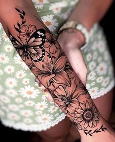 a woman's arm with flowers and butterflies on it