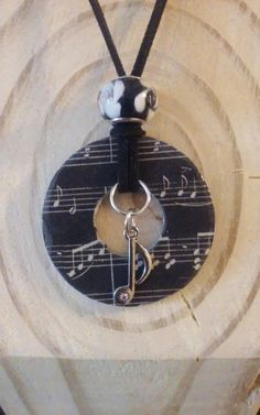 a necklace with music notes hanging from it's center circle on a black cord