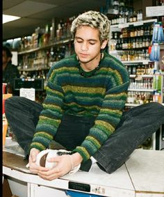 a man sitting on top of a counter in a store