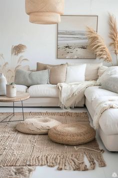 a living room filled with lots of white furniture and pillows on top of a rug