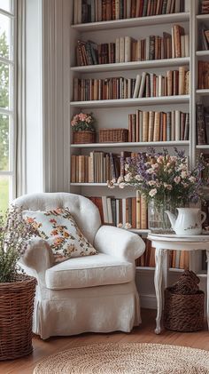 a white chair sitting in front of a book shelf filled with books