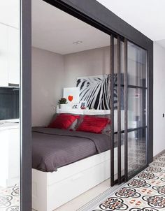 the bedroom is decorated in black and white with red pillows on it's headboard