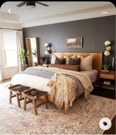 a bedroom with a large bed and two stools on the floor next to it