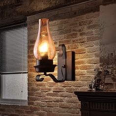 a light that is on the side of a brick wall next to a couch in a living room