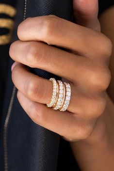 a woman's hand with three different rings on her finger and the ring is gold