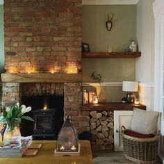 a living room filled with furniture and a fire place in front of a brick wall