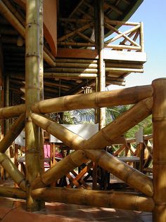 a bamboo structure with chairs and tables in the background