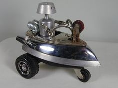 a small metal toy car with wheels on a white surface