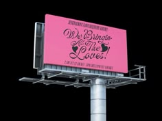 a pink billboard with the words we belong at the loves on it's side