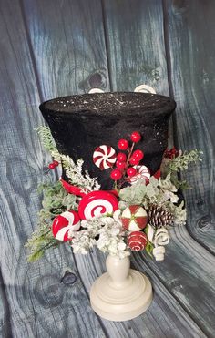 a black top hat with candy canes and greenery