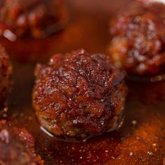 meatballs covered in sauce sitting on top of a pan