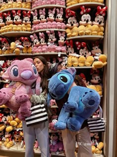 two women are standing in front of some stuffed animals