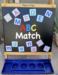 a blackboard with letters that spell out the word abc match on it and blue tray