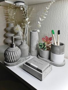 some vases with plants and toothbrushes on a table