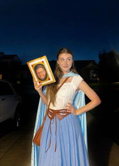 a woman in a costume holding up a photo