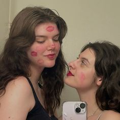 two women with makeup on their faces taking a selfie