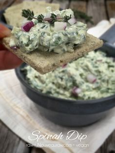 a hand holding a piece of bread with guacamole and onions on it