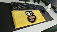 a computer keyboard and mouse on a desk with a rug in the shape of an angry bird