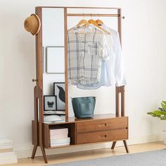 a clothes rack with two drawers and a coat hanger next to it on a wall