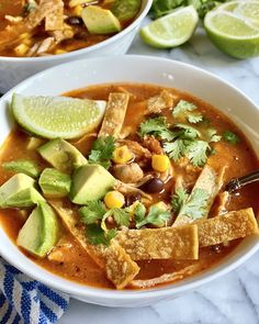 a white bowl filled with tortilla soup and garnished with avocado