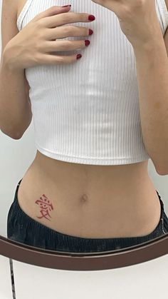 a woman taking a selfie in front of a mirror with chinese writing on her stomach