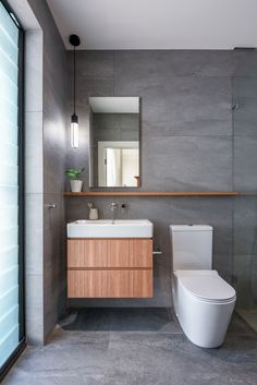 a bathroom with a toilet, sink and mirror